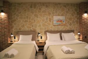 a hotel room with two beds with towels on them at Cruzeto in Syvota