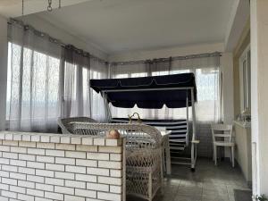 Habitación con cama, mesas de mimbre y sillas. en Vila Tosic, en Aleksandrovac