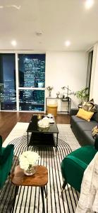 ein Wohnzimmer mit einem Sofa und einem Tisch in der Unterkunft Luxury Modern 2 Bed Flat with Balcony + City View - Canary Wharf City Center in London