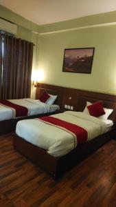 Habitación de hotel con 2 camas con almohadas rojas en Hotel Harmony Ptv Ltd, en Katmandú