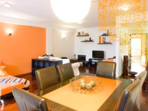 uma sala de jantar com mesa e cadeiras e uma sala de estar em Fonsi House no Porto