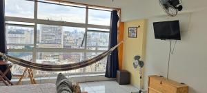 a room with a hammock in front of a large window at Loft Acolhedor Vista Incrível 2719 in Sao Paulo