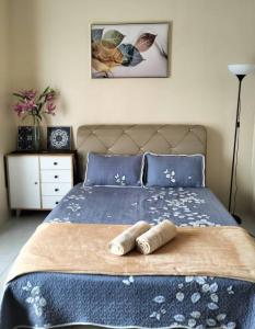 a bedroom with a bed with two towels on it at Homestay Cikgu in Pasir Gudang