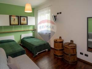 um quarto com duas camas e dois barris de madeira em Casa di vacanza nel totale relax. em Gornate Olona 