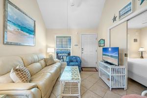 een woonkamer met een bank en een tv bij The Cove Unit 201A in Gulf Shores