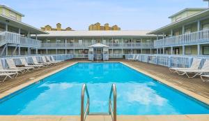 een groot zwembad met stoelen en een gebouw bij The Cove Unit 201A in Gulf Shores