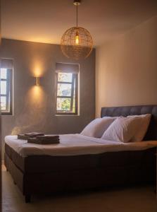 een slaapkamer met een groot bed en 2 ramen bij MAJOR. Suites Curaçao in Willemstad +29 foto's