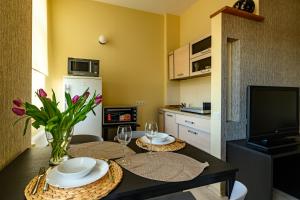 a kitchen with a table with two glasses and flowers at Center apartment Great Amber in Liepāja