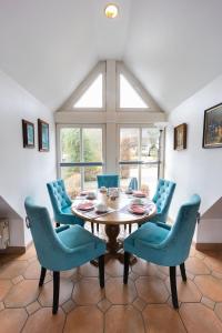 a dining room with a table and blue chairs at Landhotel Buchenhof Garni in Bad Essen