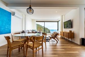 a living room with a dining room table and chairs at One Sweet World in Calheta