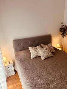 1 cama con almohadas en el dormitorio en Apartments Toma, en Kaštela