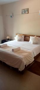 Un dormitorio con una cama grande con sábanas y almohadas blancas. en Tranquil home near vagator beach, en Anjuna