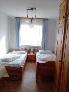 a bedroom with two twin beds and a window at Ferienhaus Frankenhöhe in Diebach