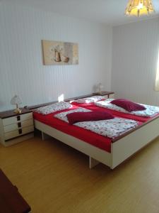 een slaapkamer met een groot bed met rode kussens bij Ferienhaus Frankenhöhe in Diebach