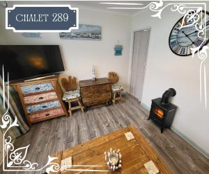 a living room with a wood stove and a clock at THE CHALETS 217 & 289 in Withernsea
