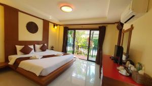 - une chambre avec un lit, une télévision et un balcon dans l'établissement Tonkhao resort, à Ban Chuang