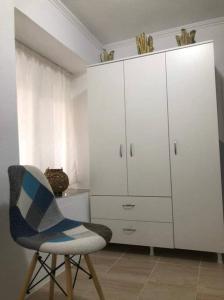a white cabinet and a chair in a room at IslandTime Studio1 in Prinos