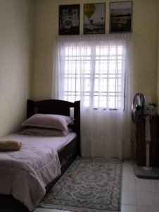 Tempat tidur dalam kamar di Homestay Cikgu