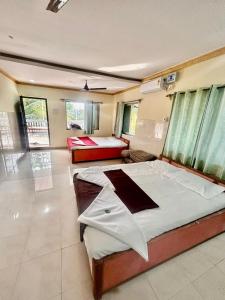 a bedroom with a large bed in a room at Vishranti resort and villa kashid beach in Alībāg