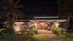 une maison avec terrasse la nuit dans l'établissement Tonkhao Resort, à Ban Chuang
