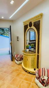 a living room with a large mirror and chairs at Luxury in Tetouan