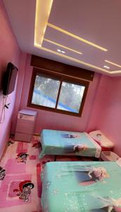 a room with two beds in a room with pink walls at Luxury in Tetouan