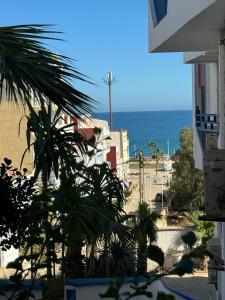 uma vista para a praia a partir de um edifício com uma palmeira em Luxury em Tétouan