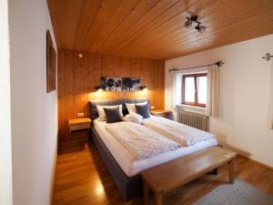 een slaapkamer met een groot bed en een houten plafond bij Beim Lenz in Schleching