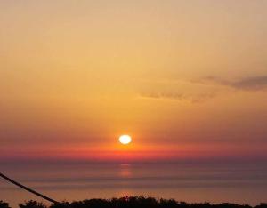 DrymonSun Castle Houses的海上日落，太阳高悬