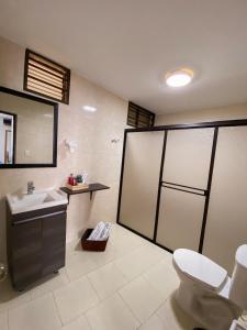 uma casa de banho com um WC, um lavatório e um espelho. em Cali View em Cali