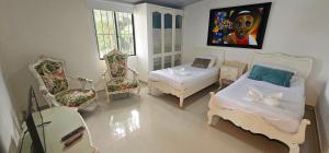 1 dormitorio con 2 camas, 2 sillas y mesa en Cabañas Cafeteras Cerritos, en Pereira 37 fotos más