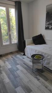 um quarto com uma cama, uma mesa e uma janela em Charmant Studio proche Paris Metro ligne 8 em Charenton-le-Pont