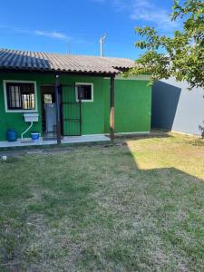 una casa verde con un patio delante en Casa Verde en Capão da Canoa