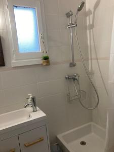 uma casa de banho com um chuveiro e um lavatório. em Cabourg, appartement T2 accès direct mer em Cabourg