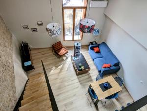 ein Wohnzimmer mit einem blauen Sofa und einem Tisch in der Unterkunft Loft d'Albenas - Clim et Bain in Loupian
