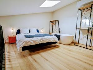 Schlafzimmer mit einem Bett und einer Badewanne in der Unterkunft Loft d'Albenas - Clim et Bain in Loupian