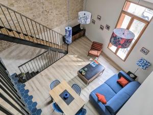 einen Blick über ein Wohnzimmer mit einem blauen Sofa in der Unterkunft Loft d'Albenas - Clim et Bain in Loupian