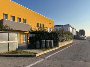a yellow building with trash cans on the side of a street at Apartment Orio Volta in Orio al Serio