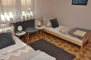 a bedroom with two beds and two tables at Apartament Pod Świerkami in Olecko