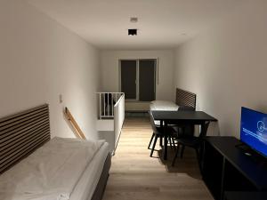 a bedroom with a bed and a table and a television at Schokoladenmuseum - Top Lage - Souterrain Apartment in Cologne