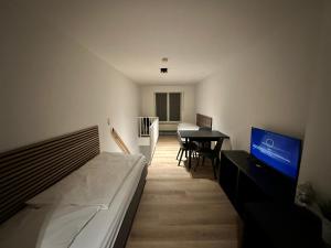 a bedroom with a bed and a table and a television at Schokoladenmuseum - Top Lage - Souterrain Apartment in Cologne