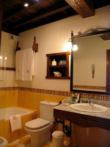 a bathroom with a sink and a toilet and a tub at Casa de Campoo in Naveda