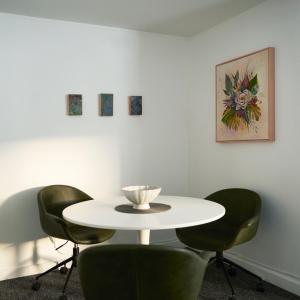 un tavolo bianco con quattro sedie verdi in una stanza di Snob Hollow Inn Downtown Anchorage ad Anchorage
