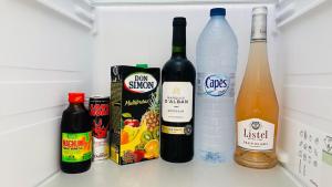 a refrigerator filled with bottles of wine and drinks at Carpe Diem Spacieux élégant et confortable appartement idéal pour les séjours professionnels in Les Abymes