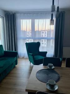 a living room with a green couch and a table at Apartament Gdańsk Ujeścisko in Gdańsk