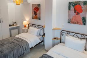 a bedroom with two beds and two pictures on the wall at Kostis Orange Resort in Volos