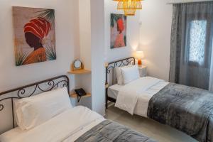 a bedroom with two beds and a clock on the wall at Kostis Orange Resort in Volos
