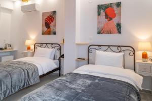 a bedroom with two beds and two paintings on the wall at Kostis Orange Resort in Volos