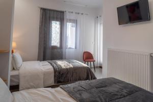 a hotel room with two beds and a window at Kostis Orange Resort in Volos