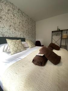 een slaapkamer met een bed met handdoeken erop bij Logement dans propriété privée 2 in Saint Julien Les Rosiers